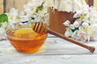 Honey in a glass jar and flower on a wooden table Honey in a glass jar and flower on a wooden table