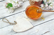Honey in a glass jar and flower on a wooden table Honey in a glass jar and flower on a wooden table