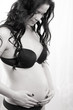 Pregnant woman caressing her belly over white background