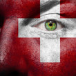 Flag painted on face with green eye to show Switzerland support