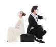 studio picture of two mimes sitting on suitcase