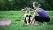Woman doing sit ups in a park with personal trainer