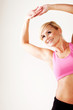 Smiling blonde woman working out stretching her arms