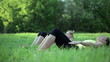 Video: Two women in sport outfit doing sit ups in a park, tracking shot Two women in sport outfit doing sit ups in a park, tracking shot