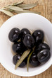 Black olives in bowl white on a wooden table Black olives in bowl white on a wooden table