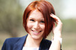 Outdoor portrait of beautiful woman with red hair