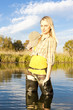 fisher woman standing in pond