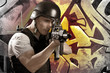 Paintball player on graffiti background with intense orange ligh Paintball player on graffiti background with intense orange ligh
