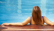 Entspannte Frau im Pool von hinten