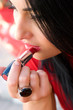 Foto: Sensual young woman applying cosmetics on her lips Sensual young woman applying cosmetics on her lips