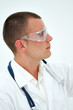 Young doctor watching through safety glasses
