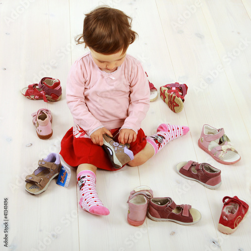 Photo: Kleinkind sucht sich ein Paar Schuhe aus Kleinkind sucht sich ein Paar Schuhe aus