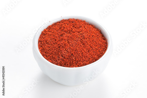 Photo: Paprika ground in a white bowl on white background. Paprika ground in a white bowl on white background.