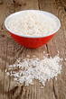 Raw white rice in bowl on wooden table