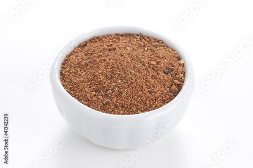 Photo: Nutmeg powder (Myristica fragrans) in a white bowl on white back Nutmeg powder (Myristica fragrans) in a white bowl on white back