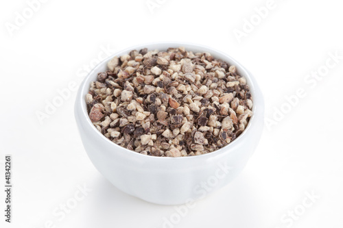 Photo: Crushed Black pepper (Piper nigrum) in a white bowl on white bac Crushed Black pepper (Piper nigrum) in a white bowl on white bac