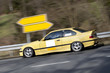 Yellow sports car flyby on the open road