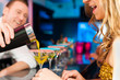 People in club or bar drinking cocktails