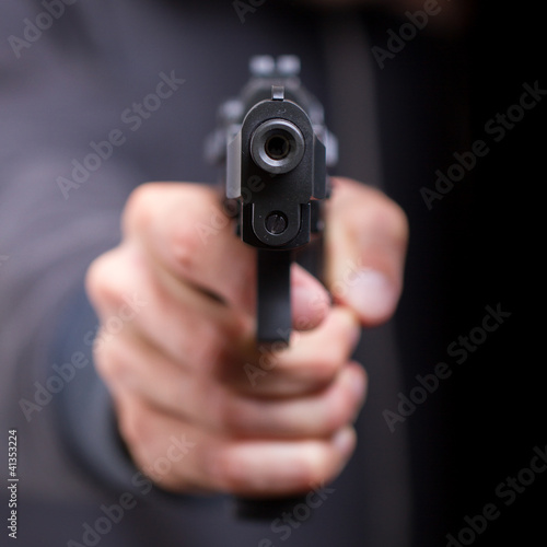 Photo: Man with gun, gangster, focus on the gun Man with gun, gangster, focus on the gun