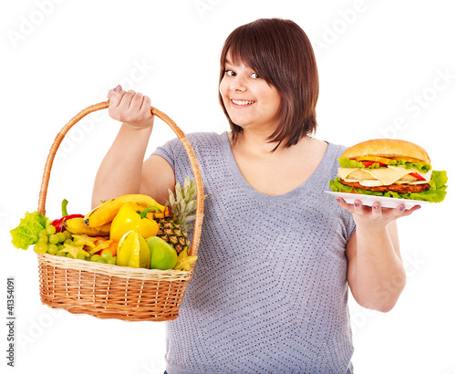 Foto: Woman choosing between fruit and hamburger. Woman choosing between fruit and hamburger.