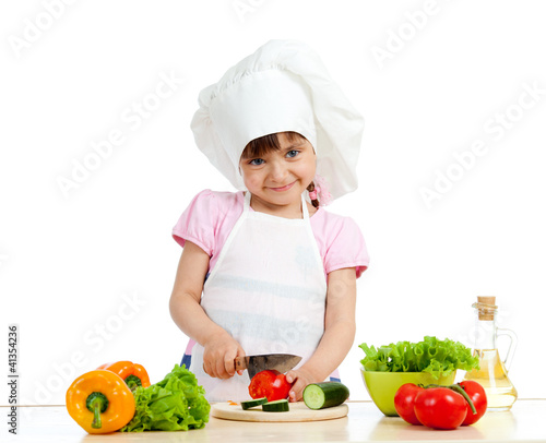 Photo: Chef girl preparing healthy food over white background Chef girl preparing healthy food over white background