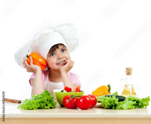 Photo: Chef girl preparing healthy food vegetable salad over white back Chef girl preparing healthy food vegetable salad over white back
