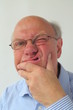 Rentner mit Hand am Kinn
