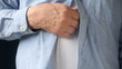 businessman scratches a persistent itch on his torso