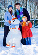 family with snowmen in garden family with snowmen in garden