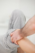 Practitioner looking at the leg of his patient