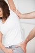 Close-up of a woman being stretched while sitting