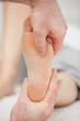 Doctor pressing his thumb on a foot