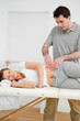 Serious physiotherapist checking the pelvis of a woman Serious physiotherapist checking the pelvis of a woman