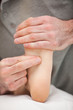 Two fingers pressing the sole of a foot
