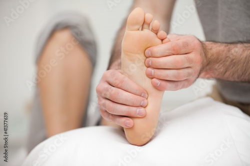 Photo: Chiropodist palpating the sole of the foot of a patient Chiropodist palpating the sole of the foot of a patient