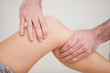Knee of a patient being touched by a practitioner