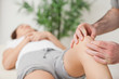 Photo: Knee of a woman being touched by a doctor Knee of a woman being touched by a doctor