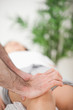 Serious doctor pressing on the knee of a woman