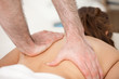 Woman lying on the belly while being massaging with two hands of