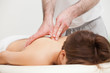 Therapist massaging the top of back of woman while standing