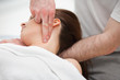 Doctor manipulating the neck of a woman while using his fingerti