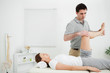 Photo: Doctor examining the leg of his patient while raising it Doctor examining the leg of his patient while raising it