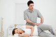 Doctor pressing his hands on the hip of his patient