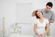 Doctor examining the neck of his patient while stretching it