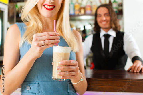 Photo: Barista with client in his cafe or coffeeshop Barista with client in his cafe or coffeeshop