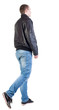 Back view of walking handsome man in jacket