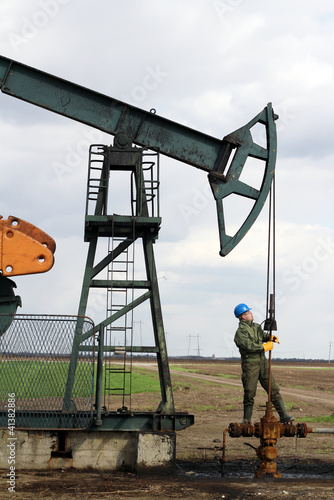 Photo: oil worker check pumpjack oil worker check pumpjack