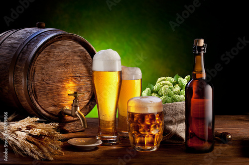 Photo: Beer barrel with beer glasses on a wooden table. Beer barrel with beer glasses on a wooden table.