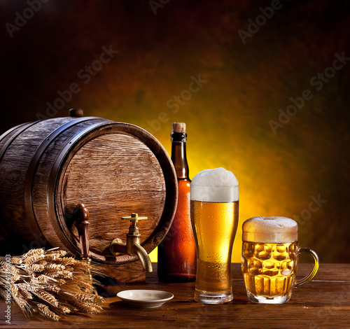 Photo: Beer barrel with beer glasses on a wooden table. Beer barrel with beer glasses on a wooden table.