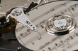 Close-up of the inside of a hard disk reflecting sheet music